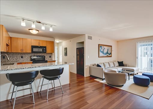 A modern kitchen with black chairs and a white countertop.