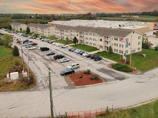 A parking lot with cars and a building in the background.