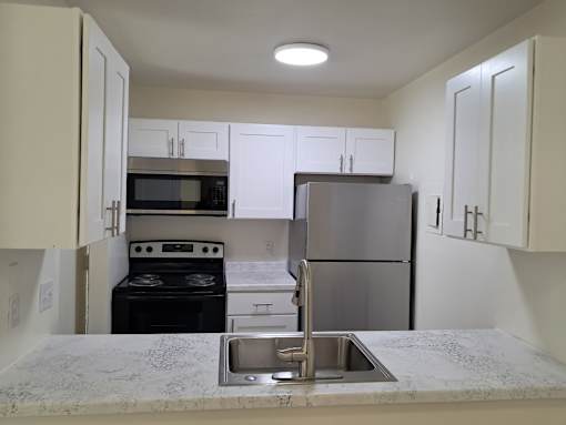 A kitchen with a stove, oven, microwave, and refrigerator.