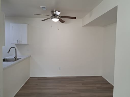 A room with a ceiling fan and a sink.