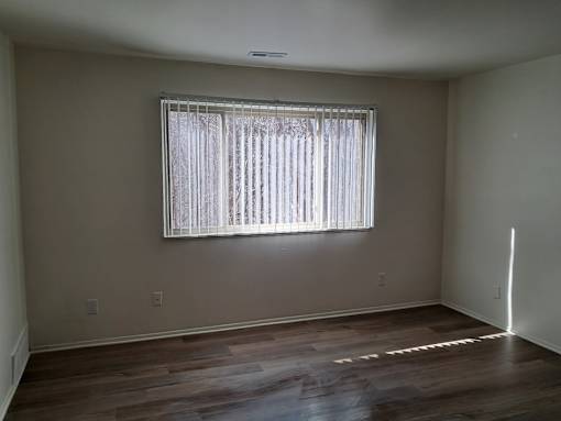 A room with a window covered by white curtains.