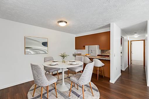 A dining room with a white table and grey chairs.