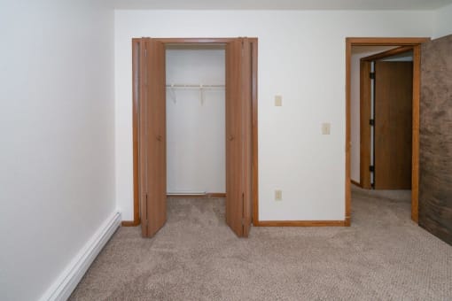 a bedroom with a closet and a door to a bathroom