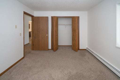 an empty room with a carpeted floor and two doors