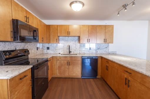 A kitchen with wooden cabinets and a marble countertop.