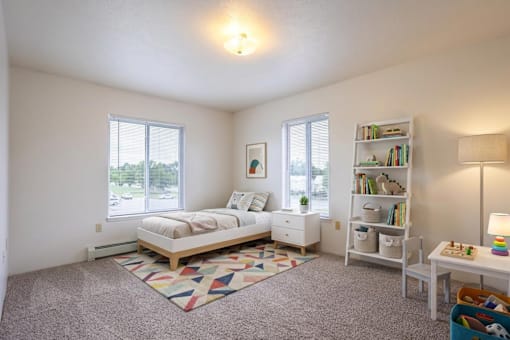 A bedroom with a bed, nightstand, and bookshelf.