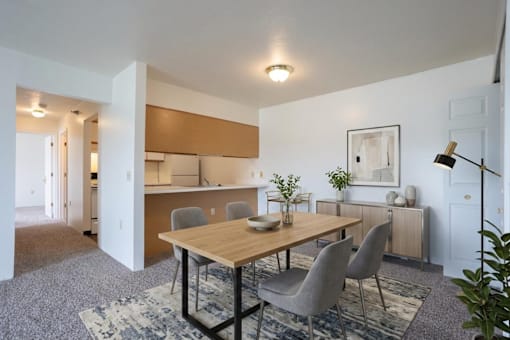 A dining room with a wooden table and grey chairs.