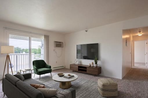 A living room with a grey couch, a green chair, a coffee table, and a television.