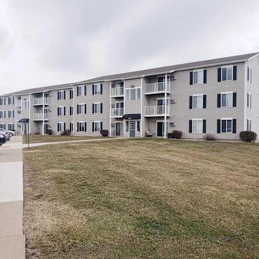 A large apartment building with multiple balconies and doors.