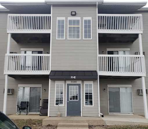 A two-story apartment building with a balcony on each floor.