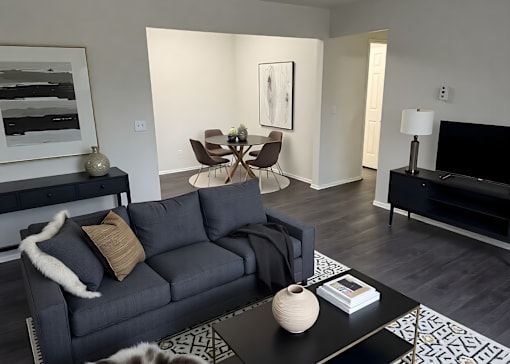 A modern living room with a grey couch and a black coffee table.