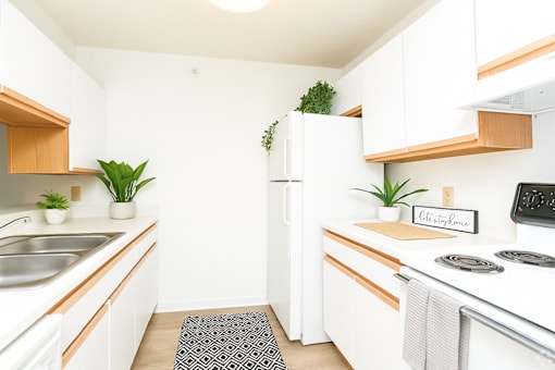 A kitchen with white cabinets and a white fridge.