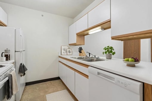 A kitchen with white appliances and wooden cabinets.