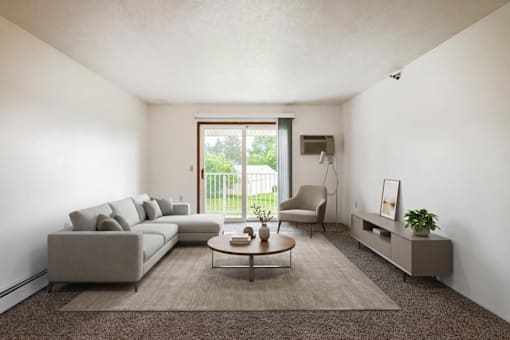 A living room with a grey sofa, a coffee table, a chair, and a plant.