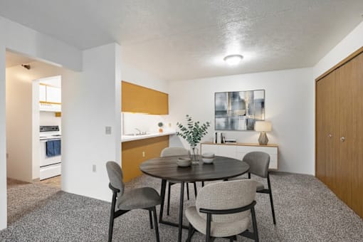 A dining room with a round table and chairs.