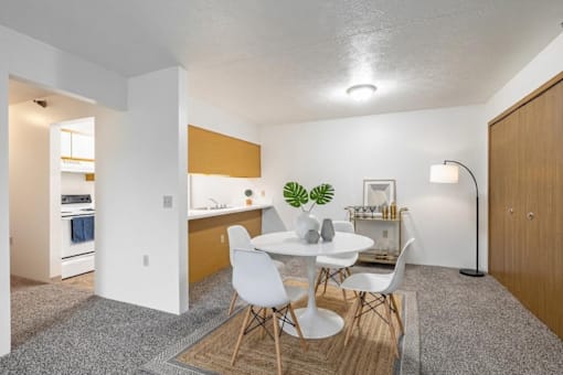 A modern dining room with a white table and chairs.