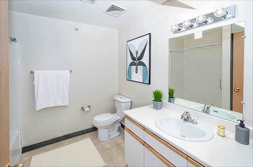 A white towel hangs on a towel rack in a bathroom.