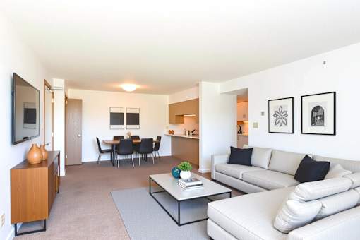 A living room with a white couch and a grey coffee table.