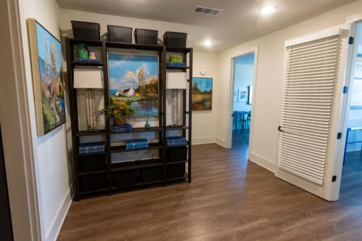 a room with paintings on the wall and a shelf with a fish tank