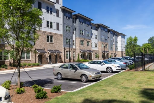 a parking lot with cars in front of an apartment building