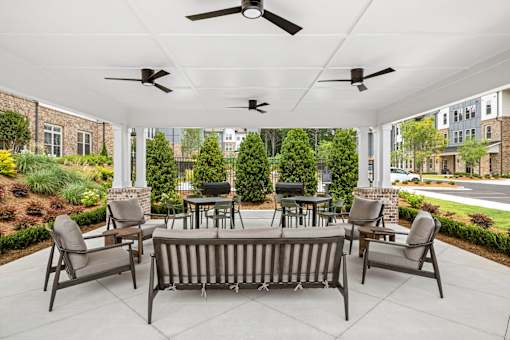 A patio with a table and chairs under a white roof.
