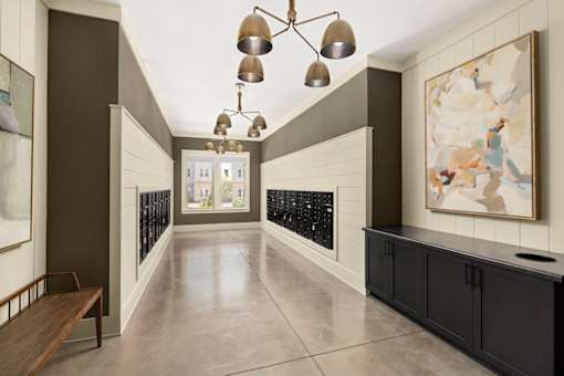 A long hallway with a bench on the left and a painting on the right.
