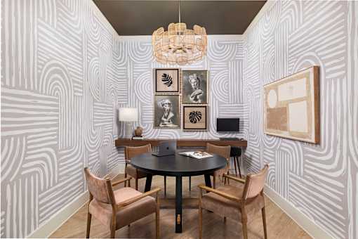 A room with a table and chairs and a wallpapered wall.