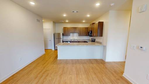 A kitchen with wooden floors and white walls.