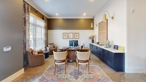 A living room with a rug, chairs, and a table.