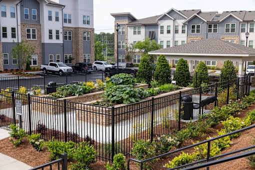 A black metal fence surrounds a small garden area.