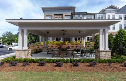 A covered patio area with a table and chairs.