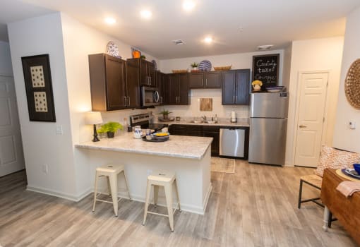 a kitchen with a large island and a stainless steel refrigerator