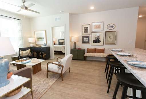 A living room with a couch, chairs, and a dining table.