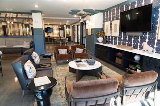 A living room with a black table and brown chairs.