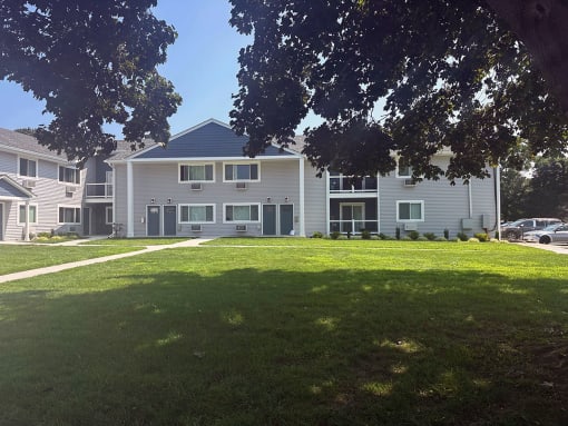 a large green lawn in front of a large gray building at Brookwood at Sayville, New York, 11782