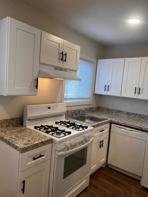 Kitchen with white cabinets and a stove and a sink at Brookwood at Bay Shore in Bay Shore, NY 11706