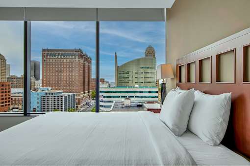 A bedroom with a large bed and a view of the city.