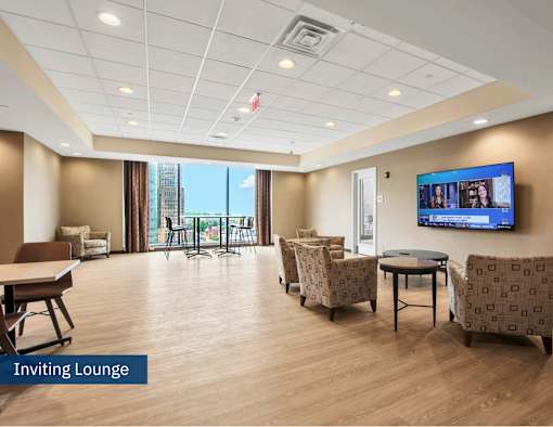 A spacious lounge area with a flat screen TV mounted on the wall.