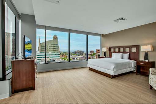 A bedroom with a large bed and a view of the city.