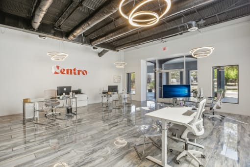 an open office space with desks and chairs and a tv