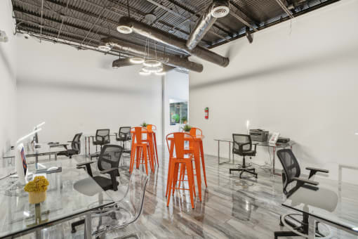 a room filled with chairs and tables and exposed pipes