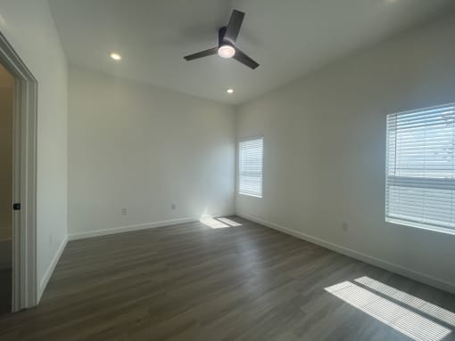 a living room with wood floors and a ceiling fan