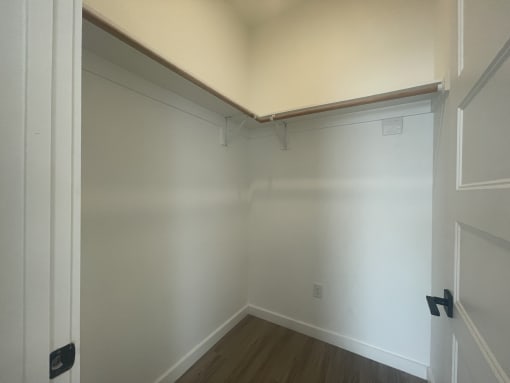 a room with white walls and a wooden floor and a white ceiling and white door