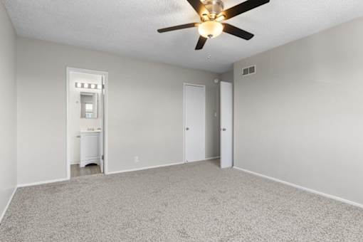 A room with a ceiling fan and a white radiator.