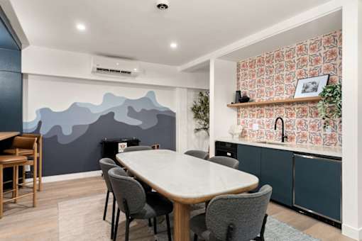A dining room with a table and chairs.