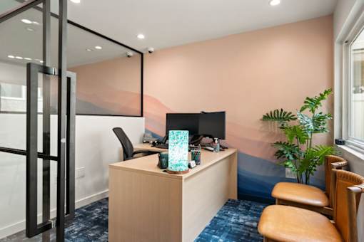 A room with a desk, chair, and a computer monitor.