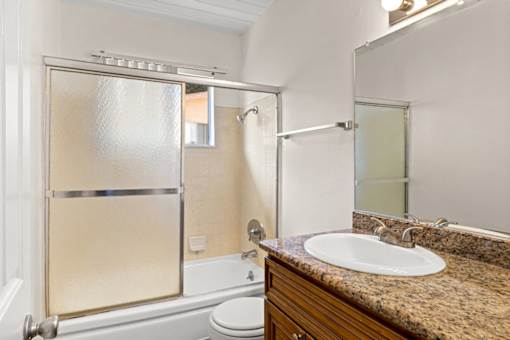 A bathroom with a sink, toilet, and shower.