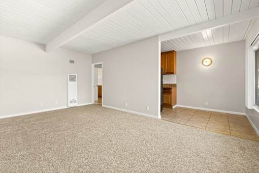 A room with a carpeted floor and a wooden door.