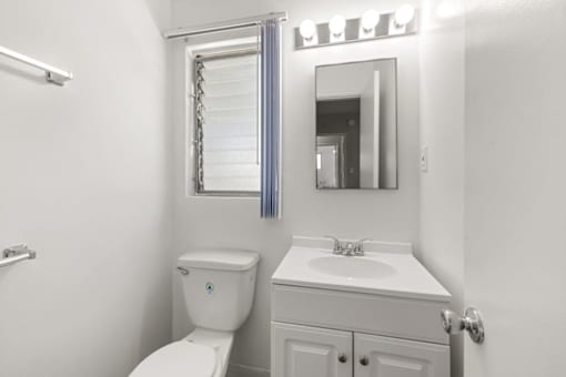 A white toilet sits next to a sink in a small bathroom.