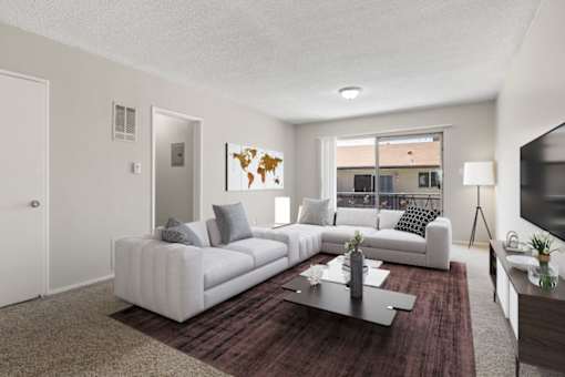 A living room with a white couch and a world map on the wall.